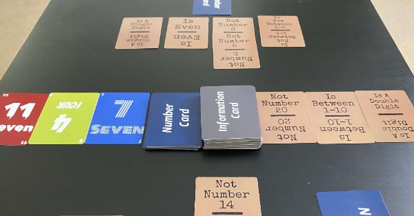 Cards being played on a table for the game Speculation