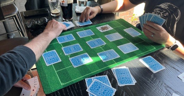 Two players playing their cards for possession of the soccer ball.